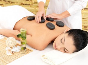 Woman having hot stone spa massage of back in beauty salon